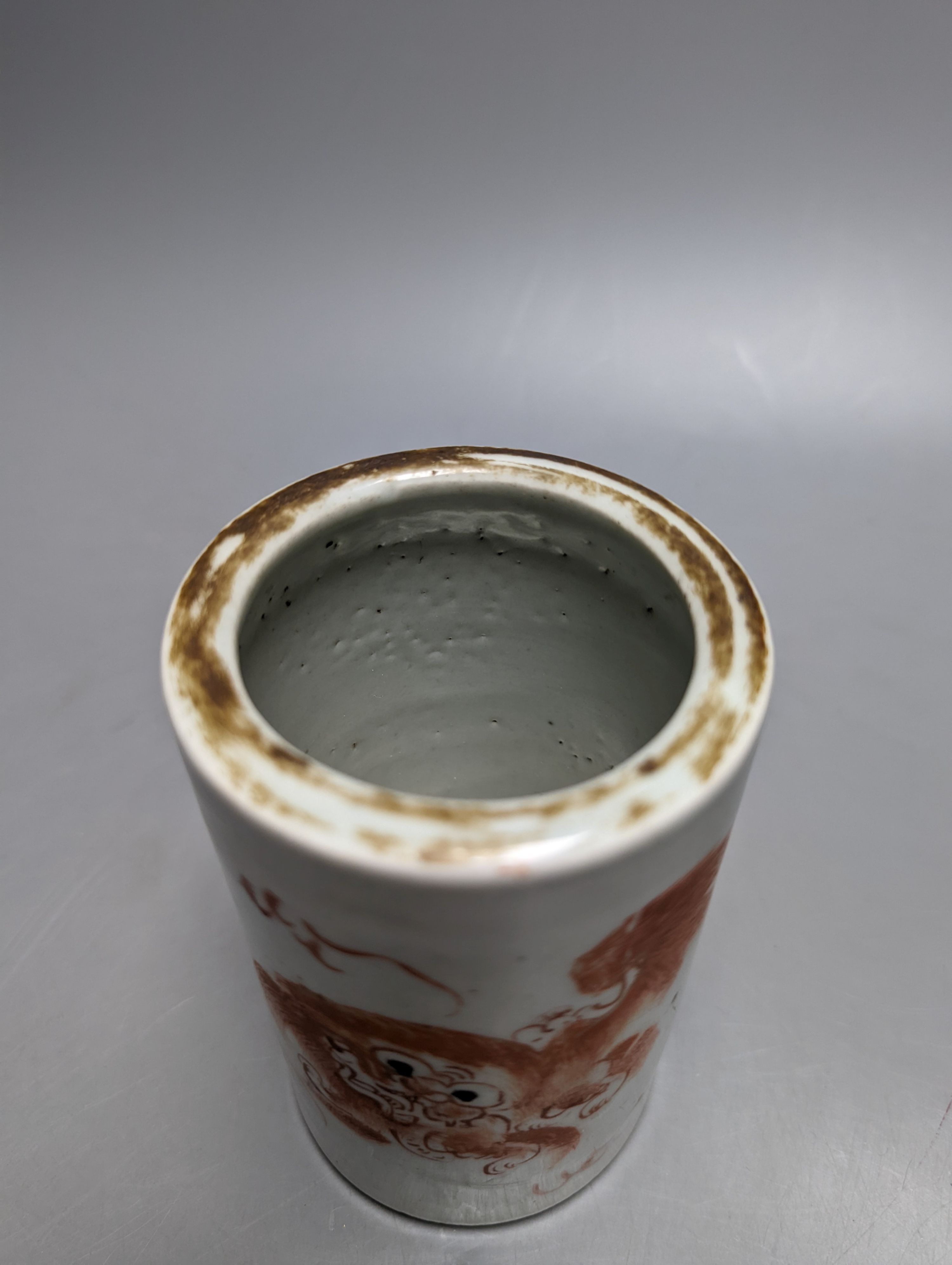An early 20th century iron red enamelled 'lion' brush pot 12cm
